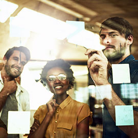 Colleagues discussing sticky note items on a board