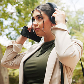 Woman putting on her headphones and holding a her phone