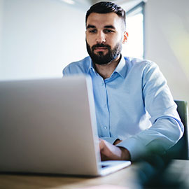 Man seated at desk on his laptop