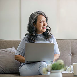 Retired woman on her laptop sitting on a couch
